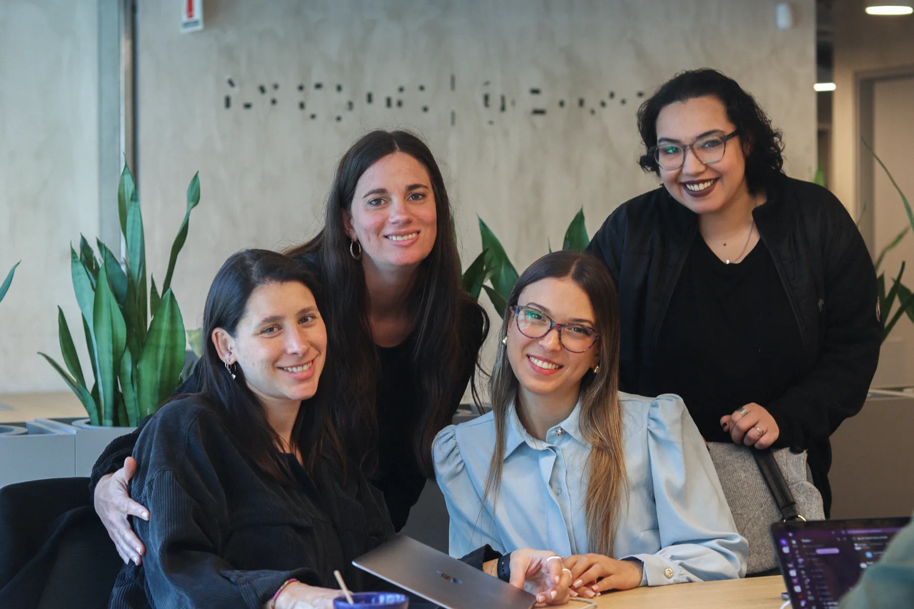 Four members of the Thaloz team smiling around a table in Buenos Aires